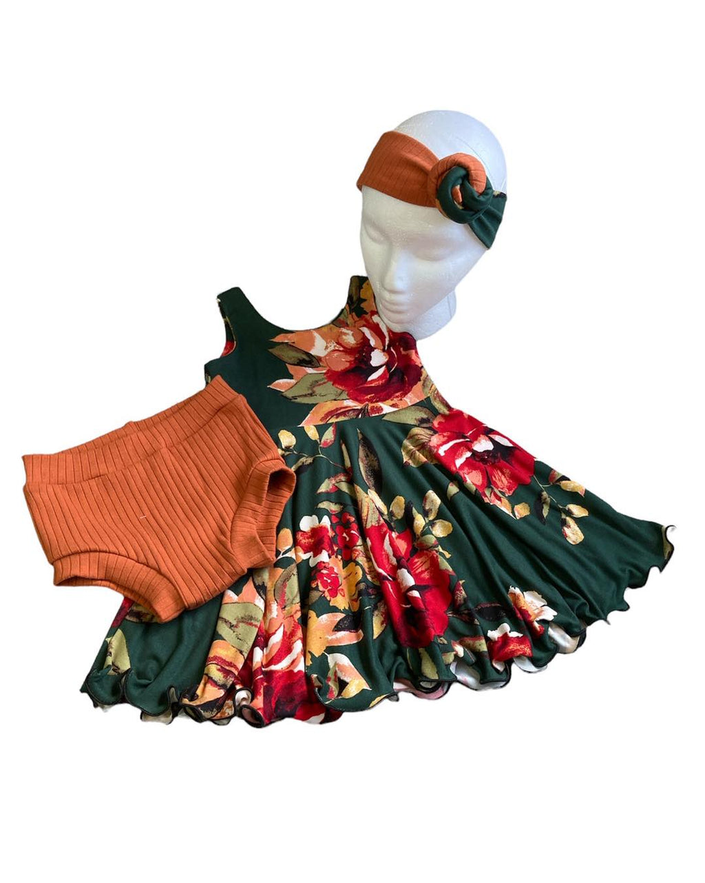 Green floral twirly dress with headband and pumpkin colored bummies on white background